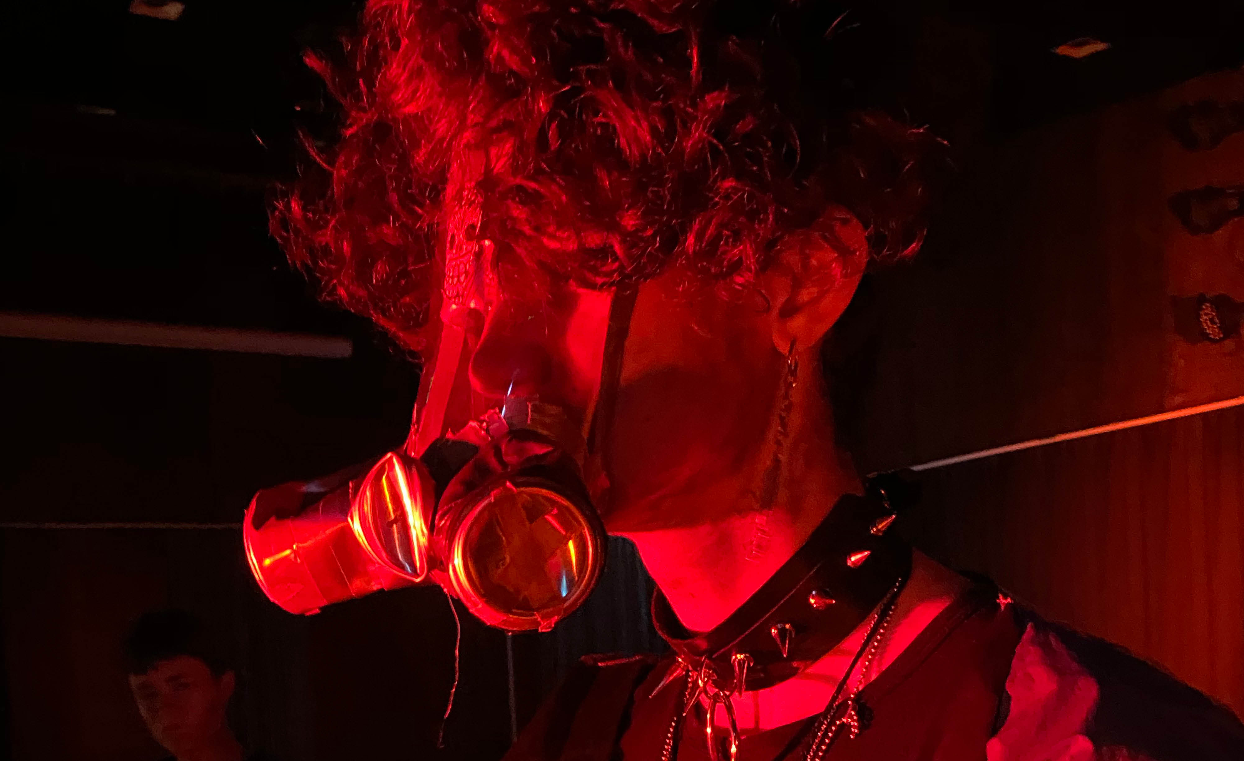 Ett ansikte med apokalyptisk mask i rött ljus.