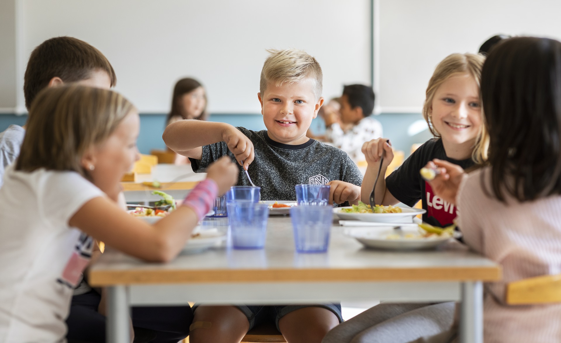 Barn som äter mat i skolmatsal