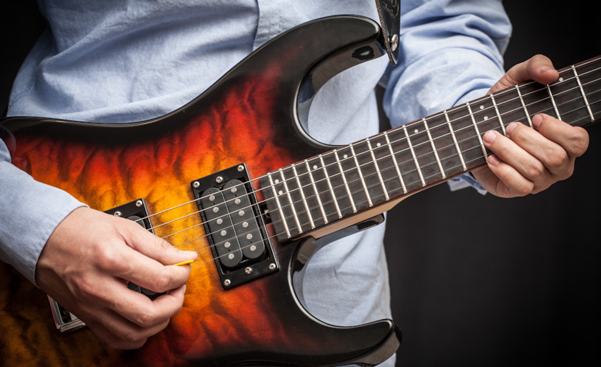 En gitarrist spelar elgitarr med ett plektrum.