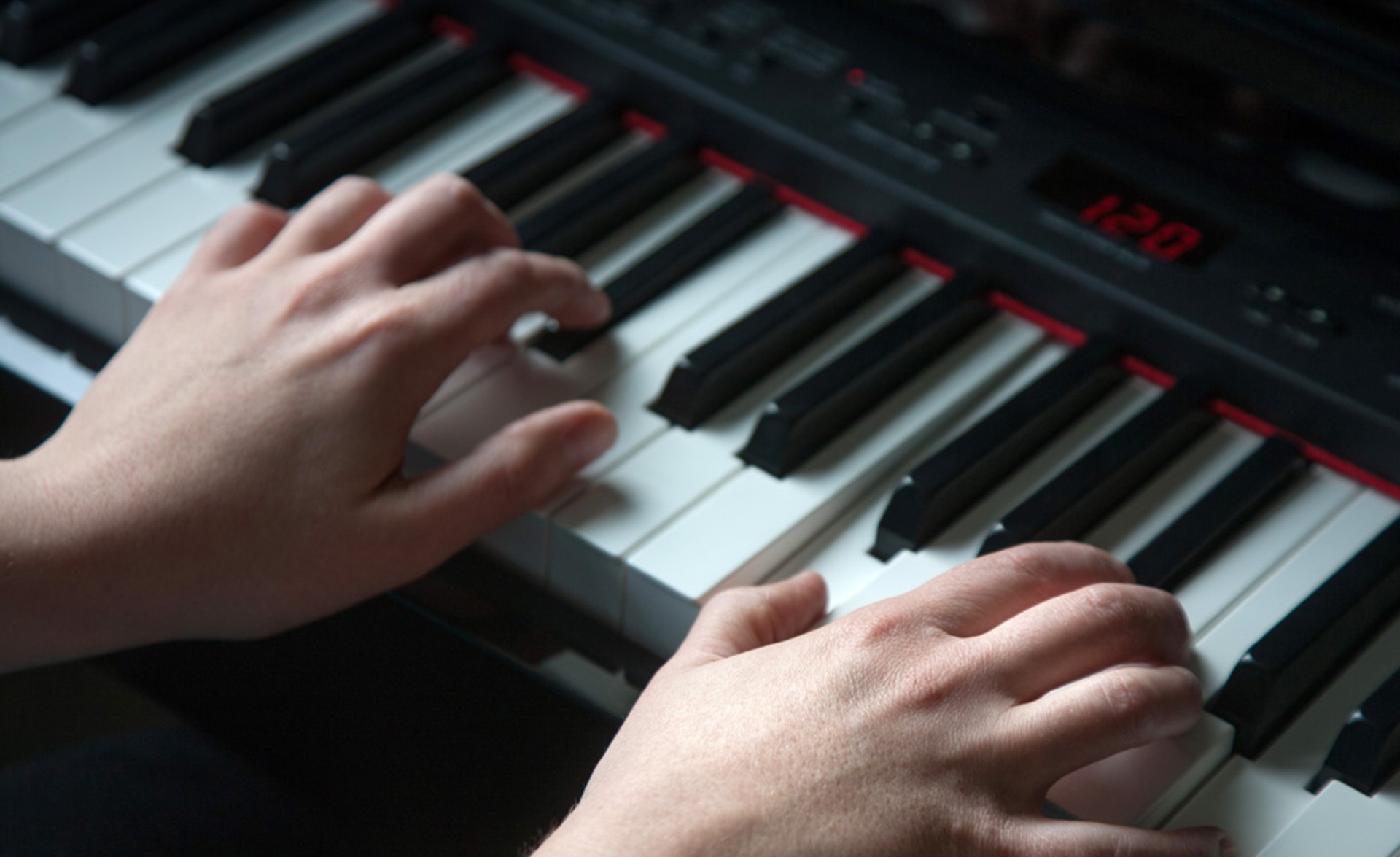 Två händer spelar på ett digitalpiano.