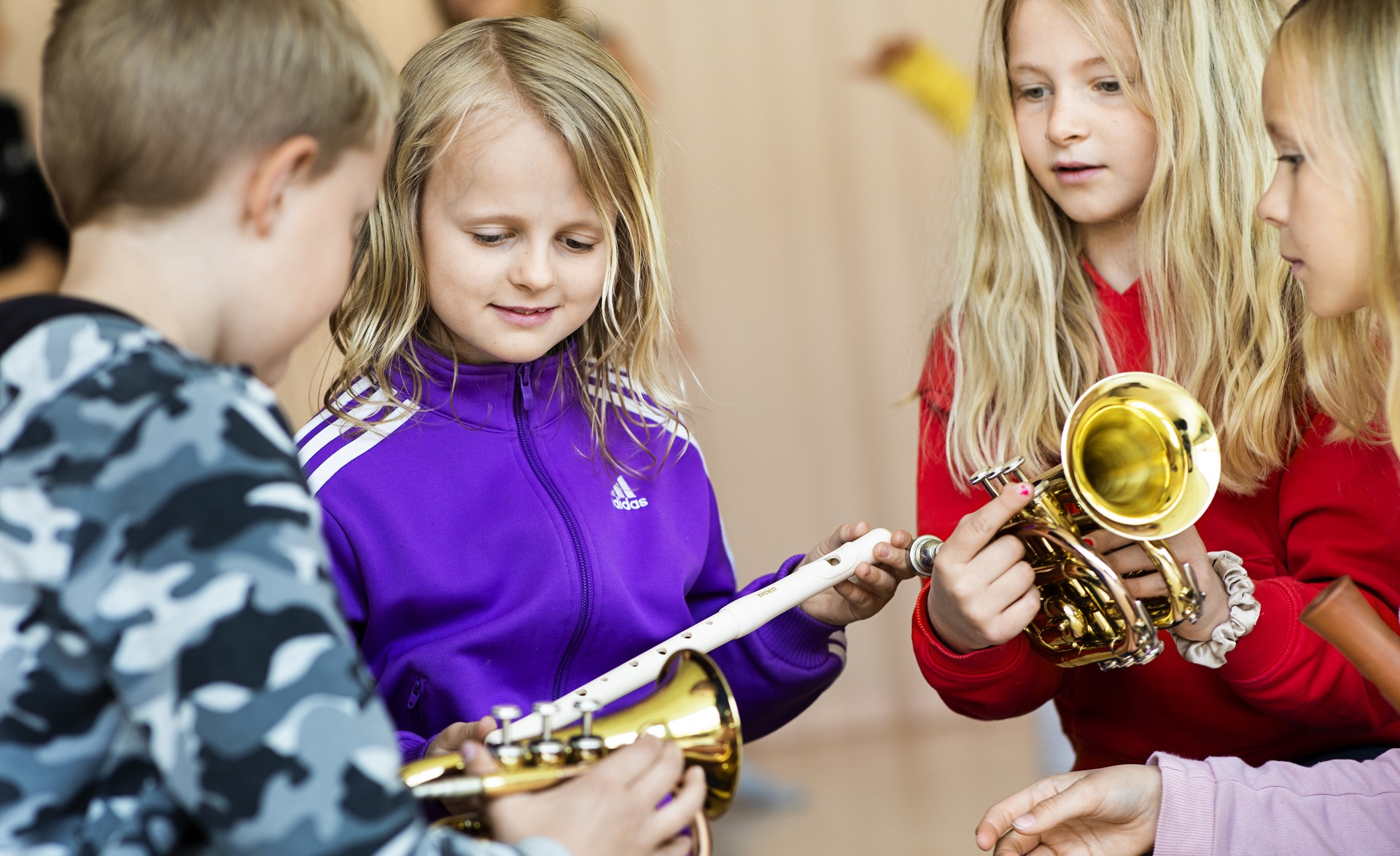 Fyra barn står och tittar nyfiket på instrument.
