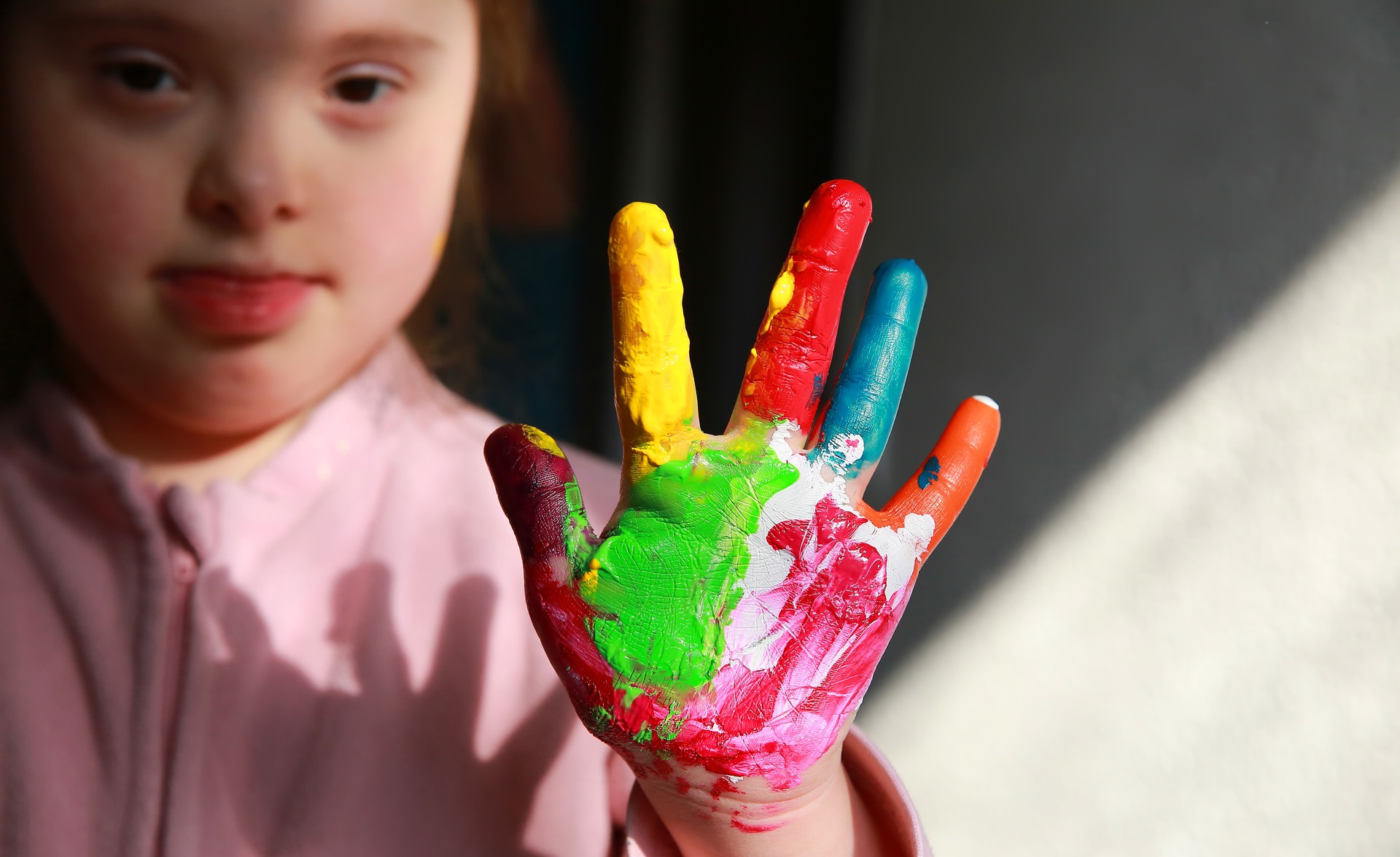 Flicka med downs syndrom med målad hand